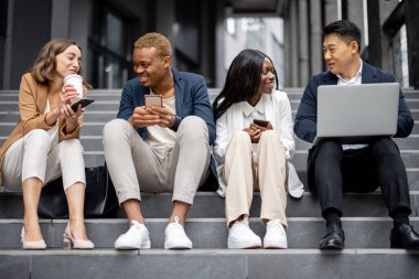 İş ekibi dijital aygıtlar kullanarak konuşuyor.