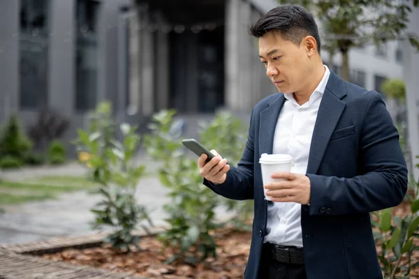 Empresário com xícara de café chamando no smartphone — Fotografia de Stock