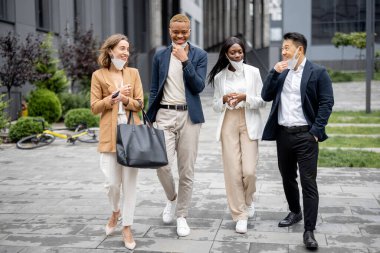 İş adamları tıbbi maskeleri çıkarıp konuşuyorlar.