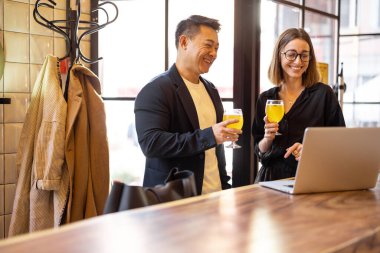 Arkadaşlar kokteyl içer ve kafede dizüstü bilgisayar kullanır.