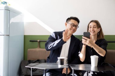 Kafede akıllı telefondan video görüşmesi yapan bir çift.