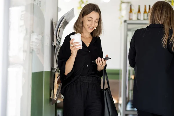 Kvinna med smartphone och kaffe i café eller butik — Stockfoto
