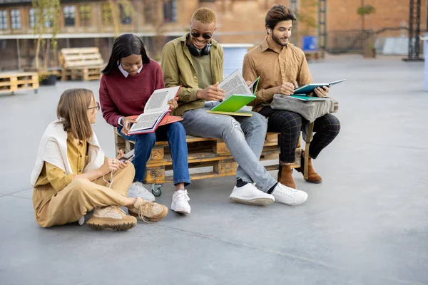 Jovens estudantes leem livros no campus universitário — Fotografia de Stock