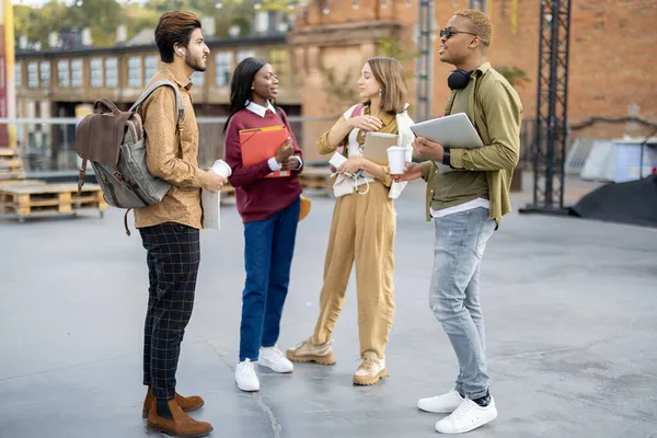 Estudiantes multirraciales se paran y hablan al aire libre durante el día —  Fotos de Stock