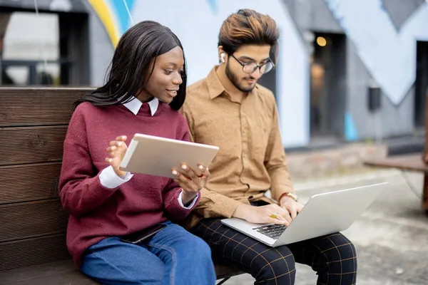 Preto menina e indiana cara com digital dispositivos — Fotografia de Stock