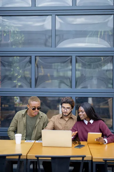 多人種間の学生は屋外のラップトップでいくつか見る — ストック写真