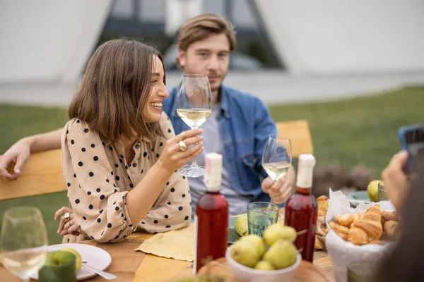ブドウ畑の近くのピクニックでワインを飲む友人 — ストック写真