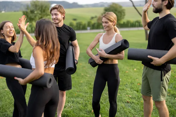 Spor paspasları olan insanlar yeşil çayırlarda dikiliyorlar. — Stok fotoğraf