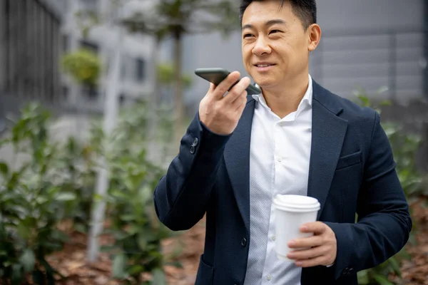 Empresario con taza de café llamando en smartphone — Foto de Stock