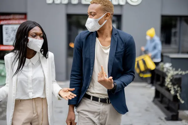 Люди в медичних масках гуляють по місту і розмовляють — стокове фото