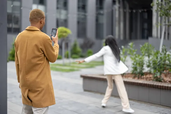 Hombre tomando fotos en el teléfono inteligente de su novia —  Fotos de Stock