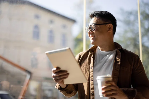 Бизнесмен пьет кофе и использует цифровой планшет — стоковое фото