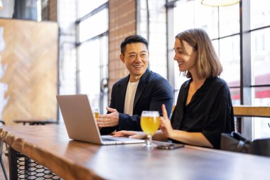 Arkadaşlar barda konuşur ve bira içerler.