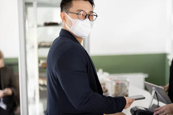 Людина в медичній масці на прийомі в магазині — стокове фото