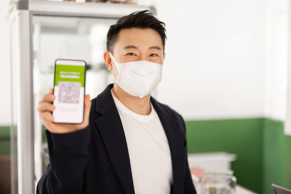Чоловік показує телефон із застосуванням Coronavirus Vaccination — стокове фото