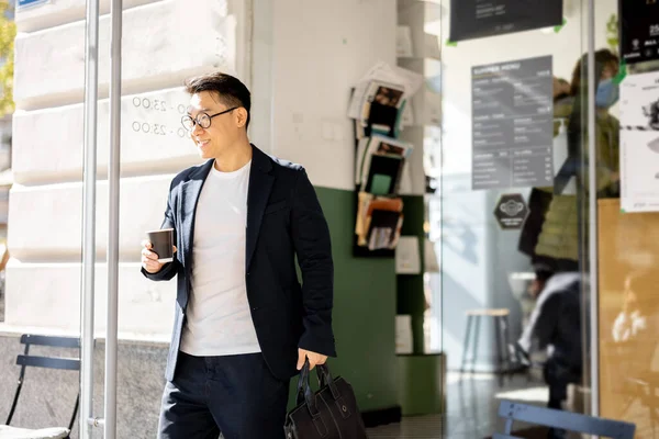 Homem com café saindo da entrada do prédio — Fotografia de Stock