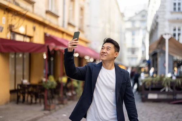 Businessman with phone in old city street — Stock Photo, Image