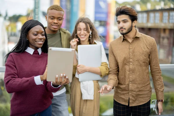 Étudiants multiraciaux regarder certains sur tablette numérique — Photo