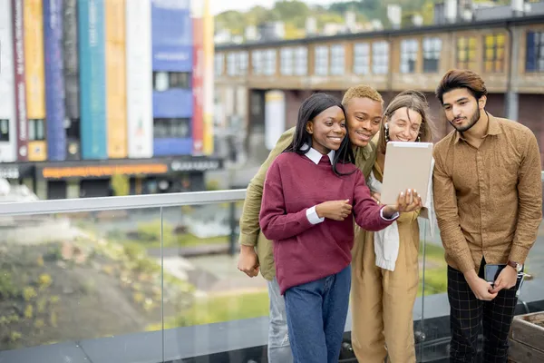 Multiracial studenter titta på några på digital tablet — Stockfoto