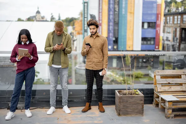 Los estudiantes usan dispositivos digitales en el campus universitario — Foto de Stock