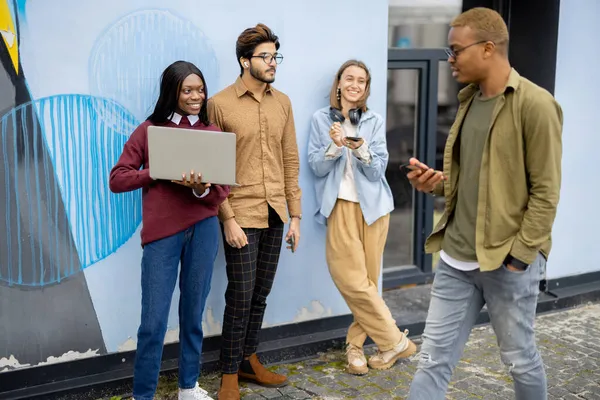 Mladí studenti používají gadgets na univerzitě budovy — Stock fotografie