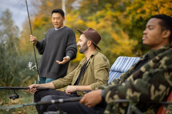 Mann spricht mit männlichen Freunden beim Angeln in der Natur — Stockfoto