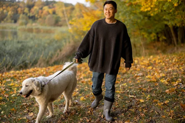 Hombre paseo con perro en la costa del río en la mañana de otoño —  Fotos de Stock