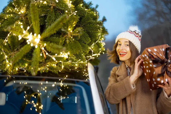 Mulher feliz com presentes e árvore de Natal ao ar livre — Fotografia de Stock