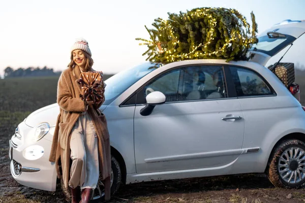 Mulher feliz com presentes e árvore de Natal ao ar livre — Fotografia de Stock