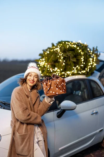 Glückliche Frau mit Geschenken und Weihnachtsbaum im Freien — Stockfoto