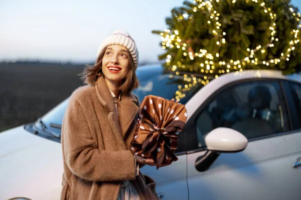 Boldog nő ajándékokkal és karácsonyfával a szabadban — Stock Fotó