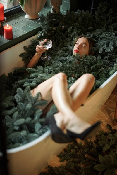 Γυναίκα γιορτάζουν την Πρωτοχρονιά διακοπές στην μπανιέρα γεμάτη από κλαδιά nobilis — Φωτογραφία Αρχείου