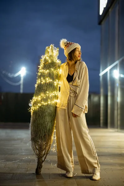 Mujer con árbol de Navidad iluminado cerca del centro comercial —  Fotos de Stock