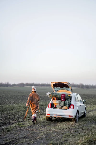 Mulher e carro cheio de caixas de presente de Ano Novo na natureza — Fotografia de Stock