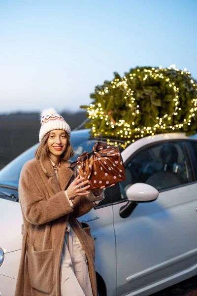 Glückliche Frau mit Geschenken und Weihnachtsbaum im Freien — Stockfoto