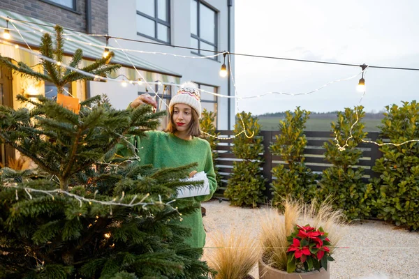 Mulher decorando árvore de Natal no quintal — Fotografia de Stock