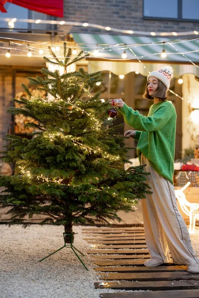 Woman decorating Christmas tree at backyard — Stock Photo, Image