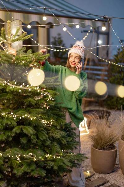 Frau schmückt Weihnachtsbaum im Hinterhof — Stockfoto