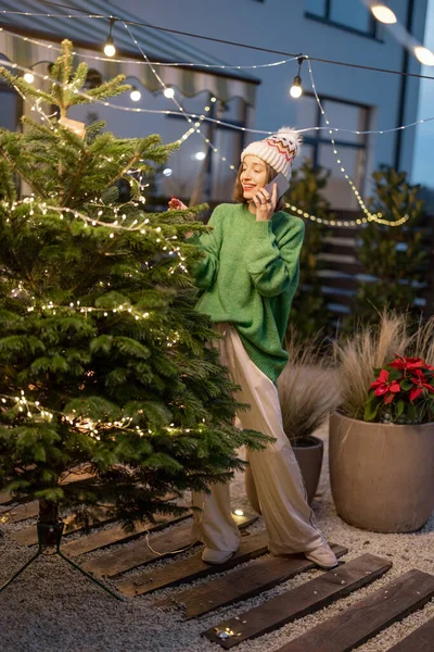 Mujer decorando árbol de Navidad en el patio trasero —  Fotos de Stock