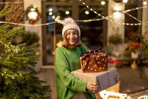 Woman with gift boxes at New Years decorated backyard — Stock Photo, Image