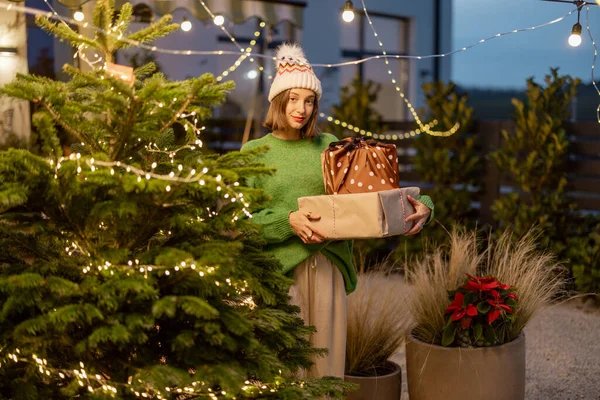 Frau mit Geschenkboxen an Silvester dekoriert Hinterhof — Stockfoto