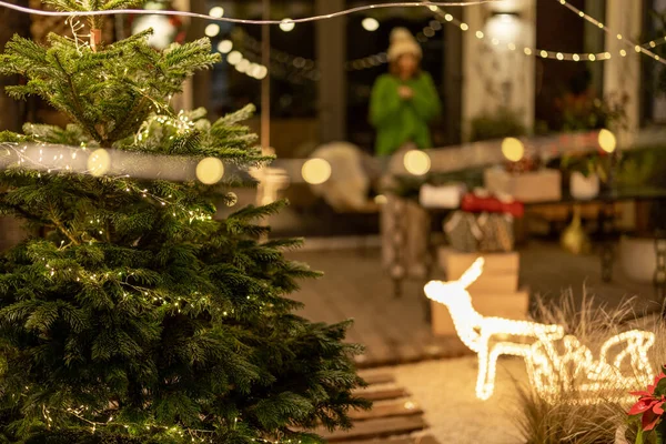 Silvester geschmückter Hinterhof mit Weihnachtsbaum und Frau — Stockfoto