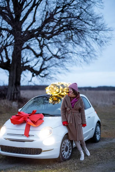 A nő autóval viszi a karácsonyfát. — Stock Fotó