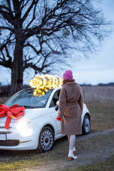 Mulher carrega árvore de Natal de carro — Fotografia de Stock