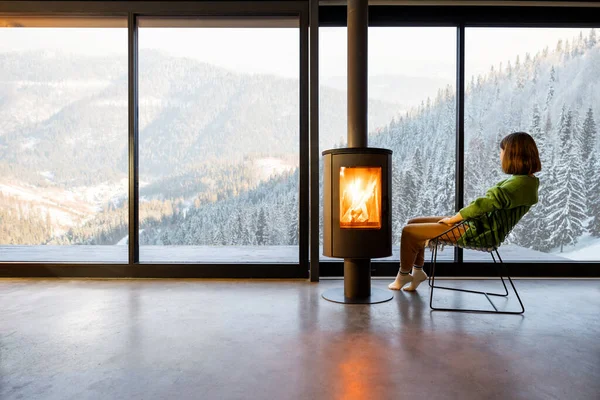 Woman enjoy great view on mountains while sitting at home near fireplace — Stock Photo, Image