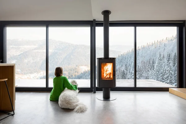 Kobieta z psem w domu w górach w zimie — Zdjęcie stockowe