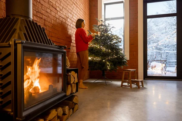 Útulný obývací pokoj interiér se ženou zdobení vánoční stromeček — Stock fotografie