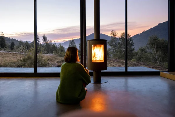 Donna godere di una splendida vista sulle montagne mentre seduto a casa vicino al camino — Foto Stock