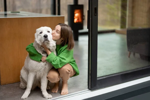 Mladá žena se svým psem v moderním domě na přírodě — Stock fotografie