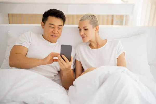 Muž ukazující něco na smartphonu přítelkyni — Stock fotografie